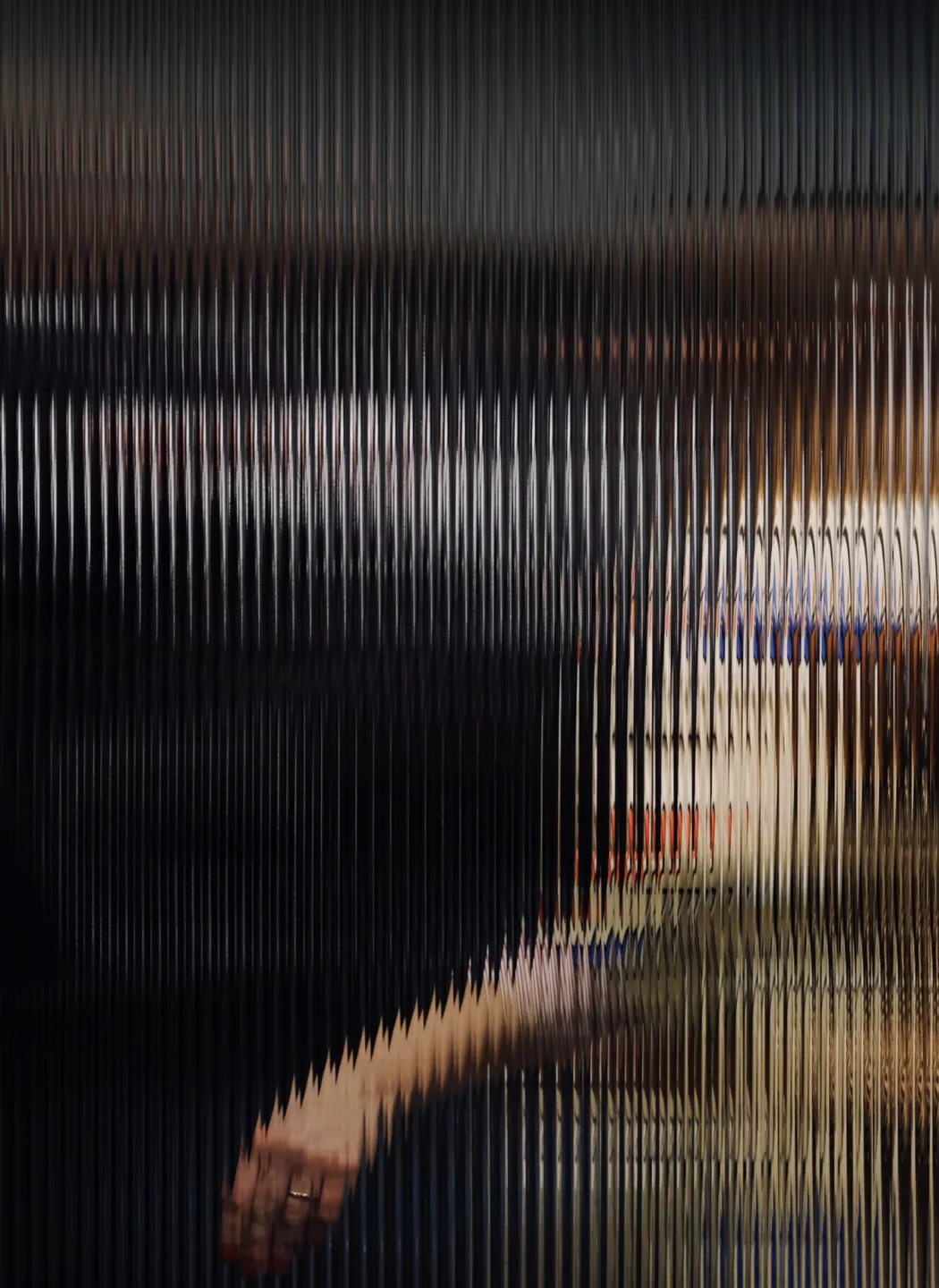 Person walking behind a fluted glass window