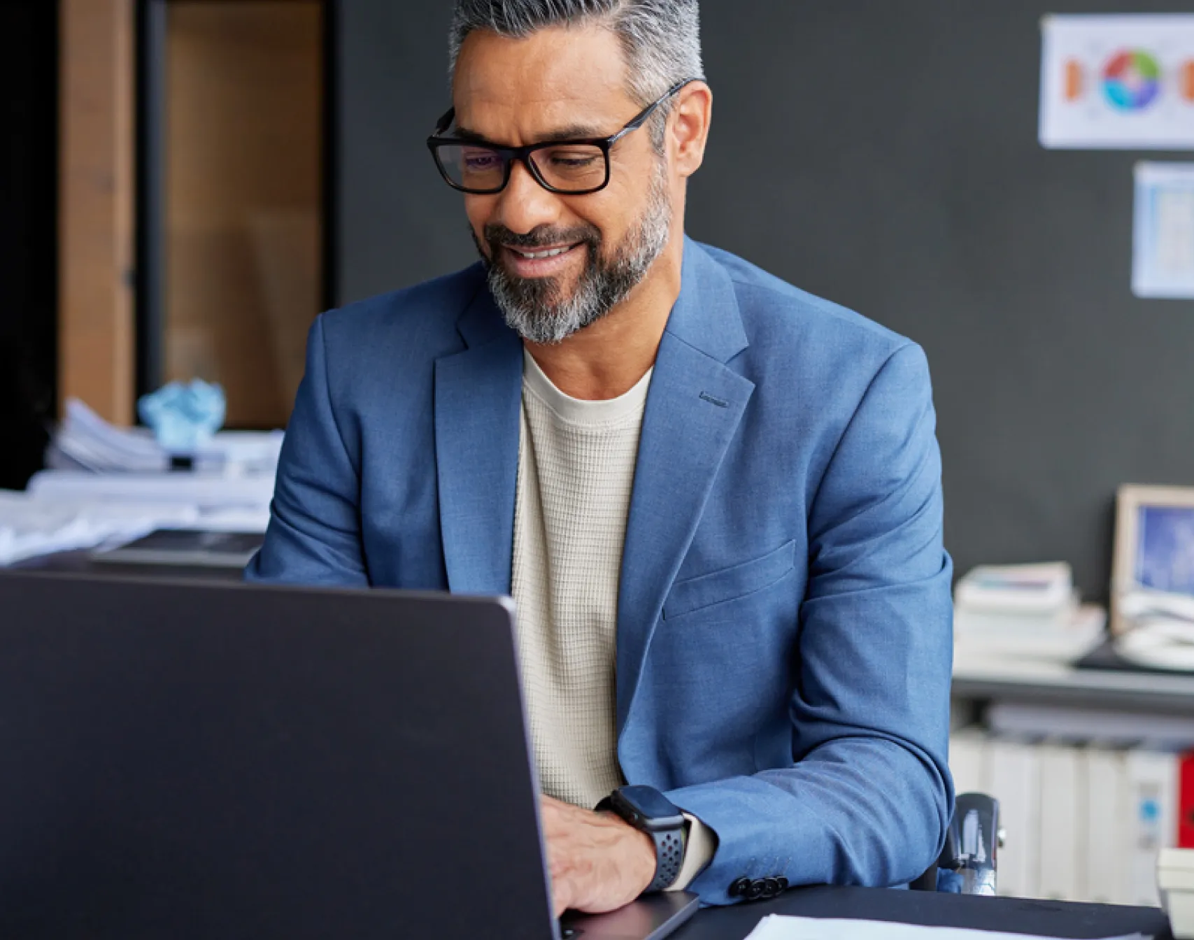 Man working at his desk, using a laptop