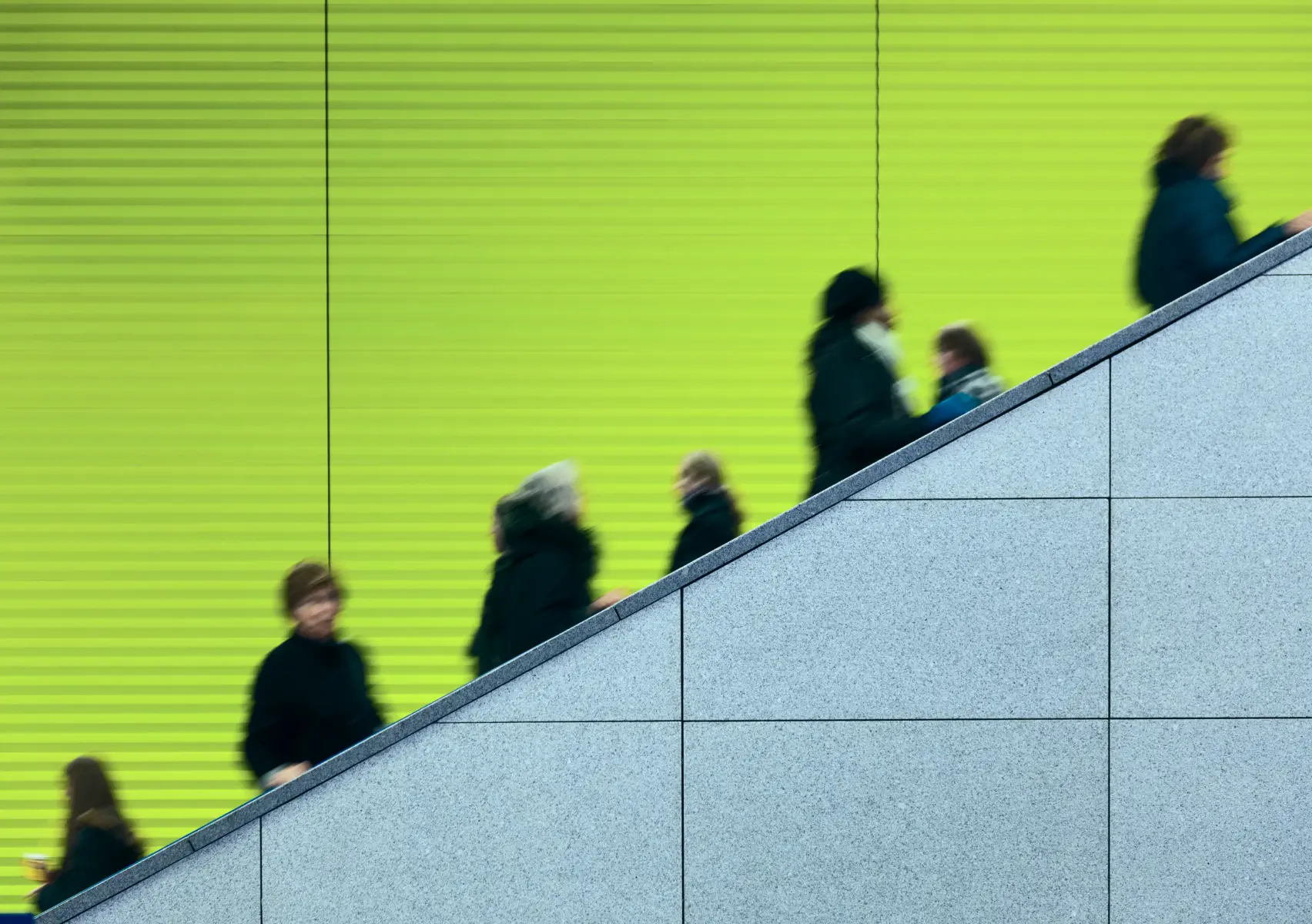 Blurred people using an escalator