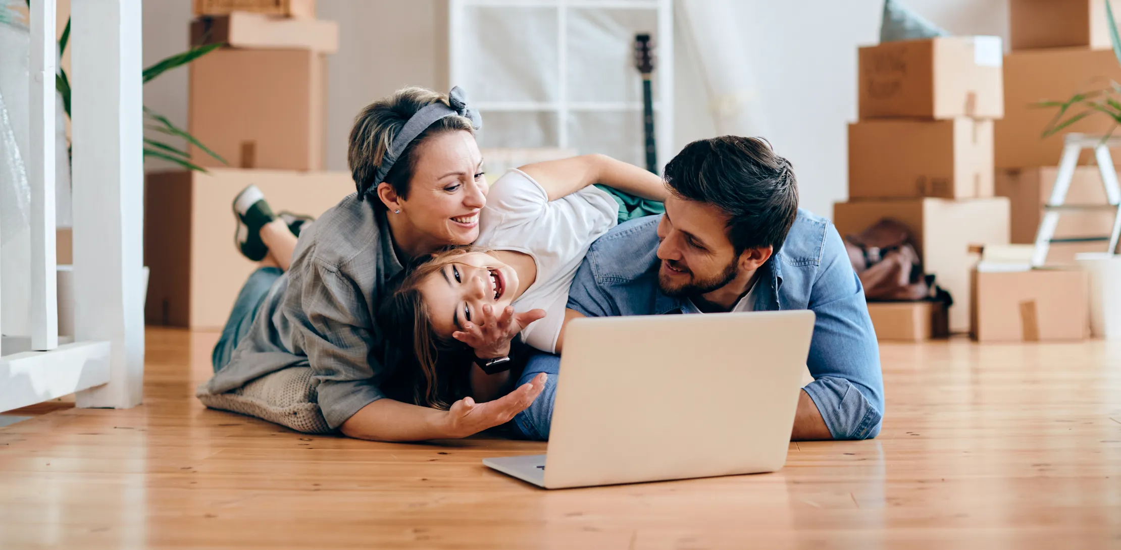 Mom, Dad, and young daughter on floor with laptop