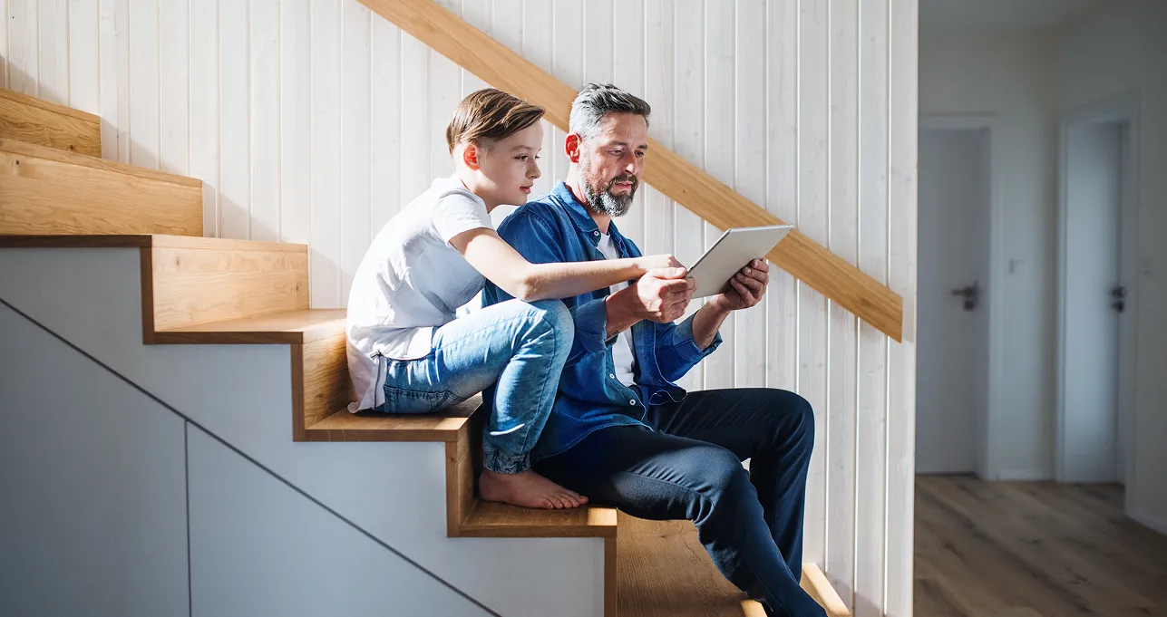 Father and son look at a tablet together