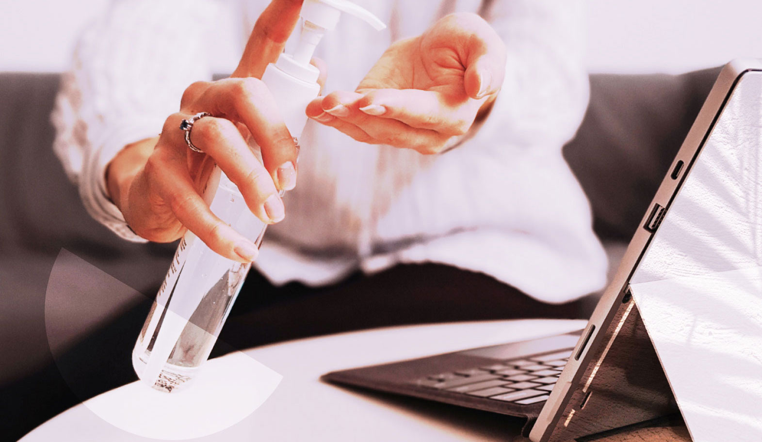 A person applying hand sanitizer before touching their computer