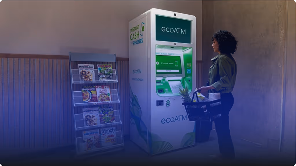 Person standing with a shopping basket in front of an ecoATM kiosk for recycling phones and receiving instant cash.