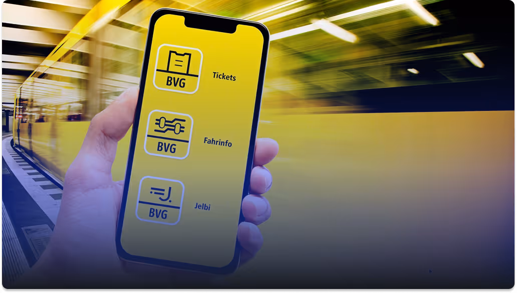 Hand holding a smartphone displaying BVG app options: Tickets, Fahrinfo, and Jelbi on a yellow background.