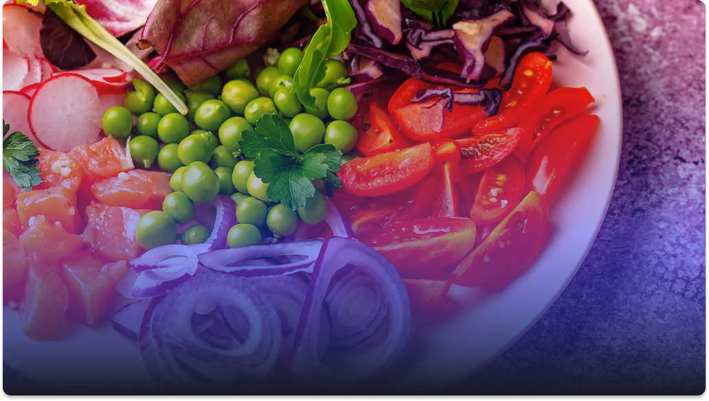 Close-up of a salad plate with peas, sliced tomatoes, red onion, radishes, and leafy greens.