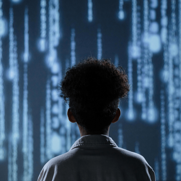 A young boy viewing a digital screen with data streams, symbolizing technology interaction.