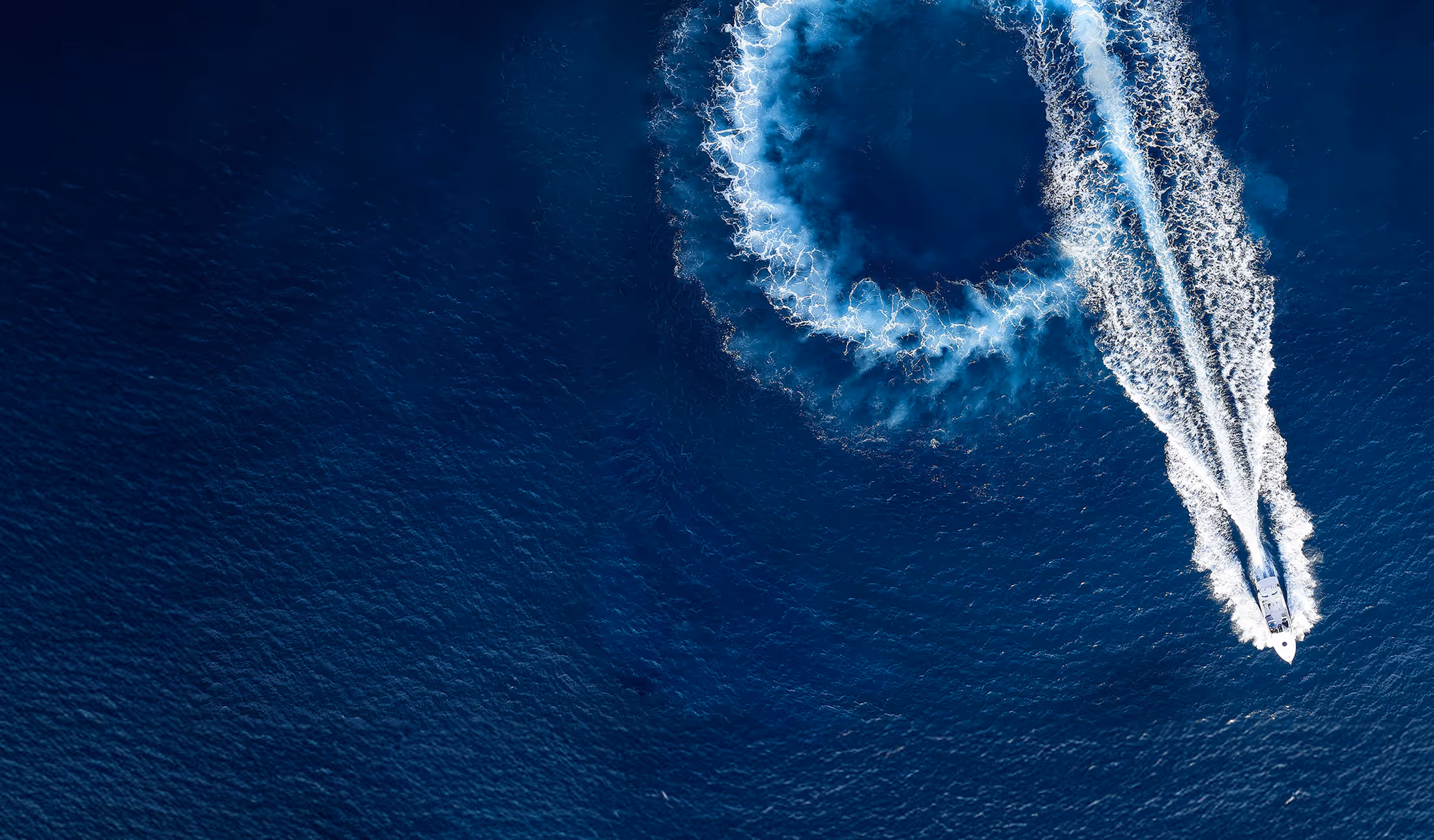 An overhead shot of a boat making the number nine in its wake.