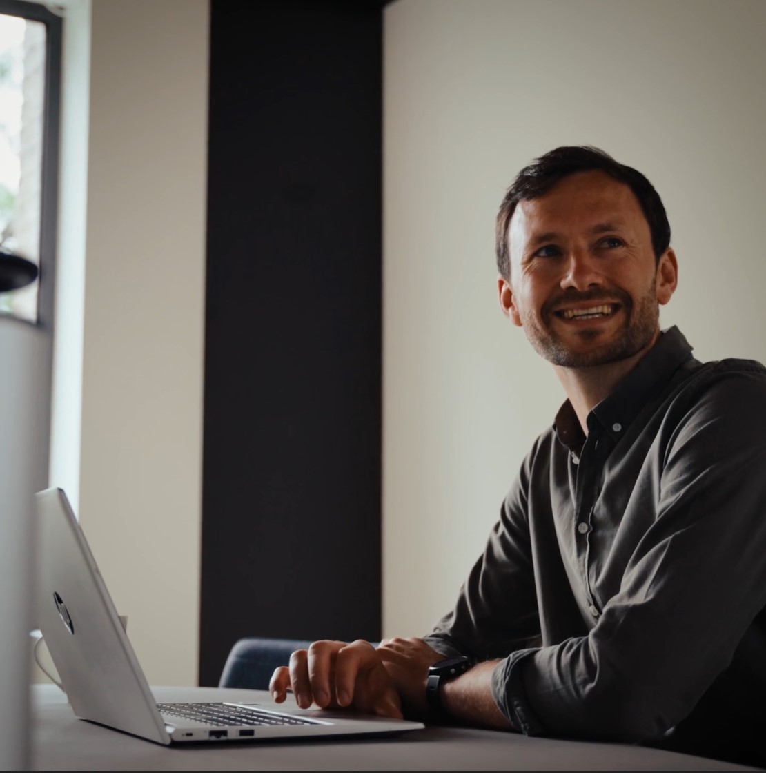 Collègue souriant derrière un ordinateur