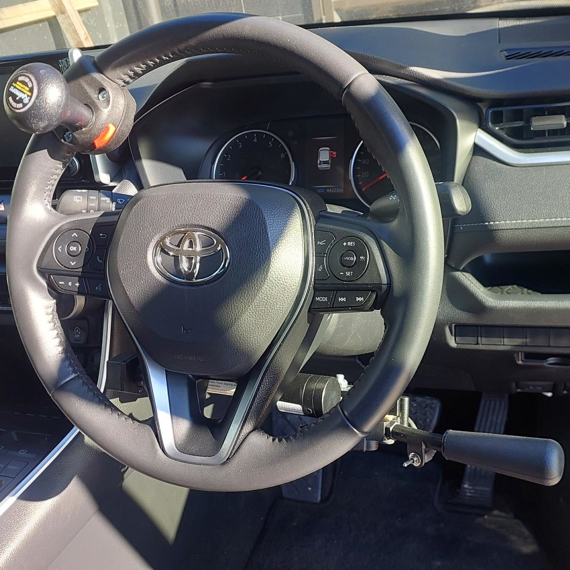 A vehicle steering wheel with control rods.