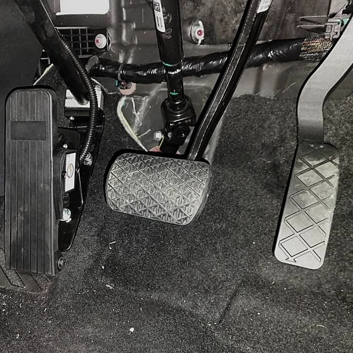 Three pedals in a vehicle foot well.
