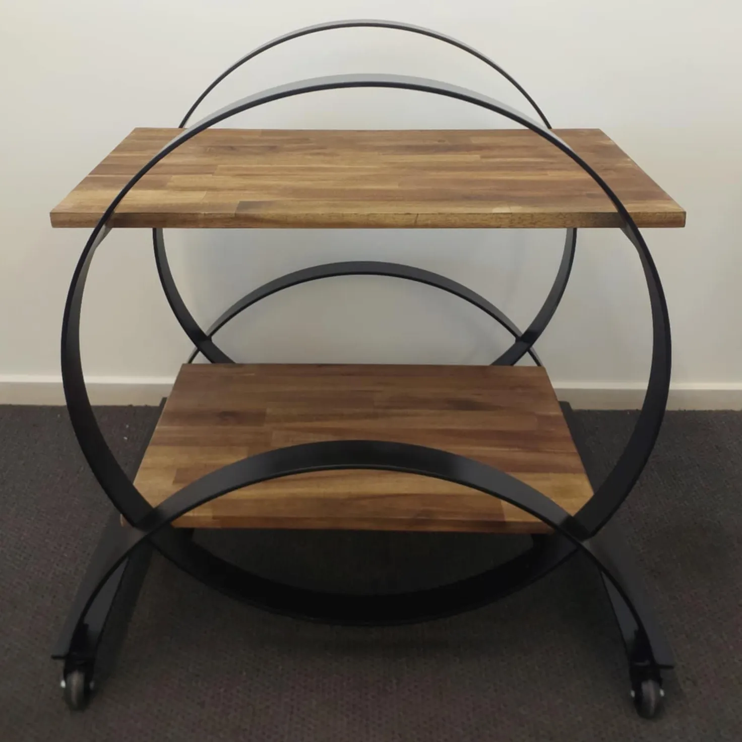 Beautiful and modern two-tiered coffee table on casters, bound by metal framing.