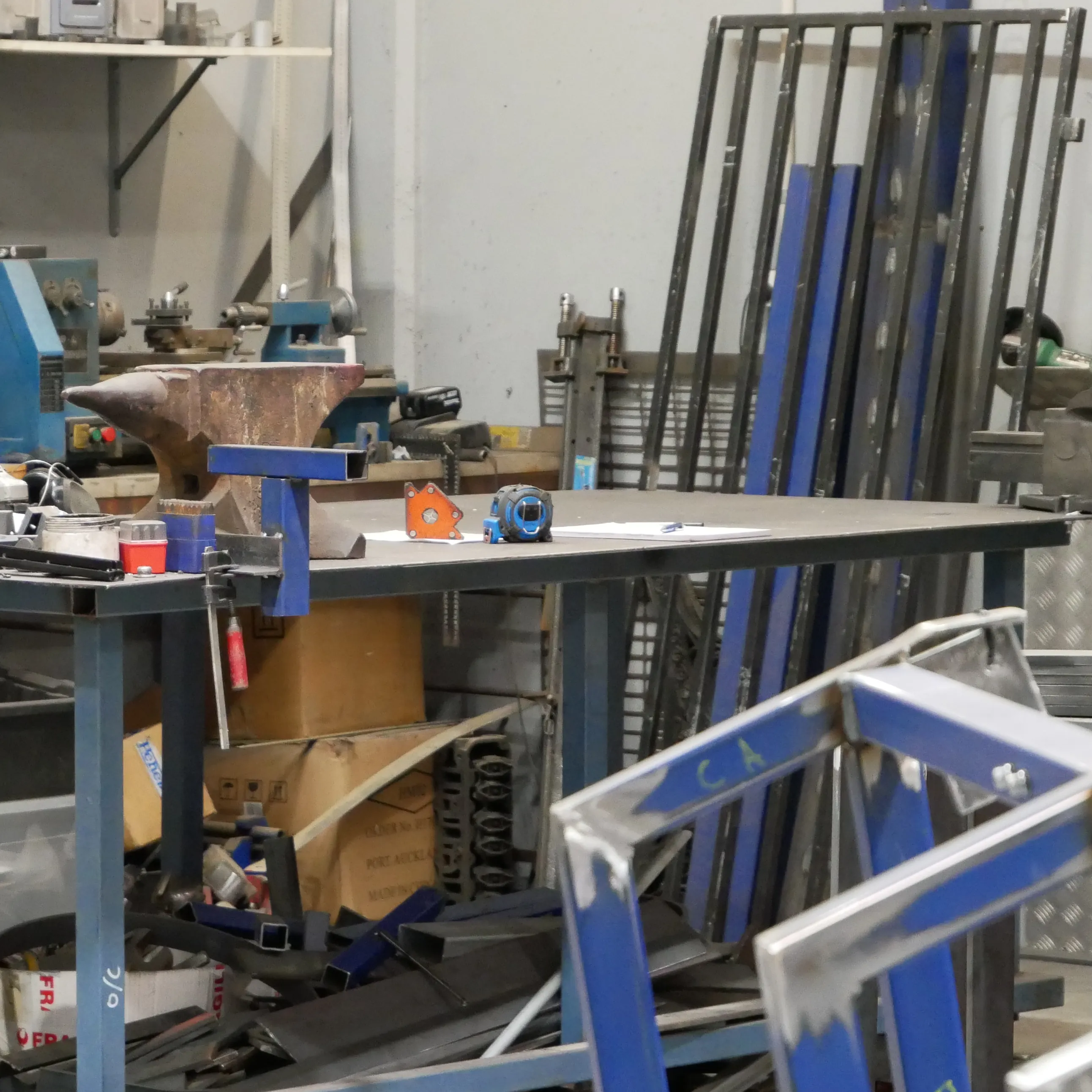 Prepared metal framing visible with workbench and tools in the background