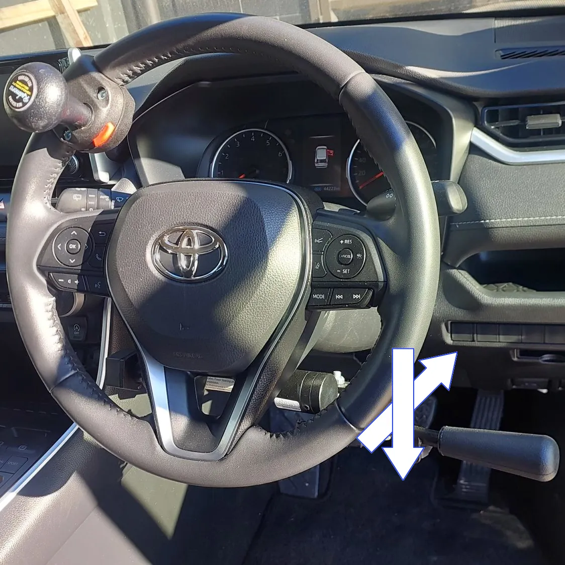 A vehicle steering wheel with control rods showing operating directions.