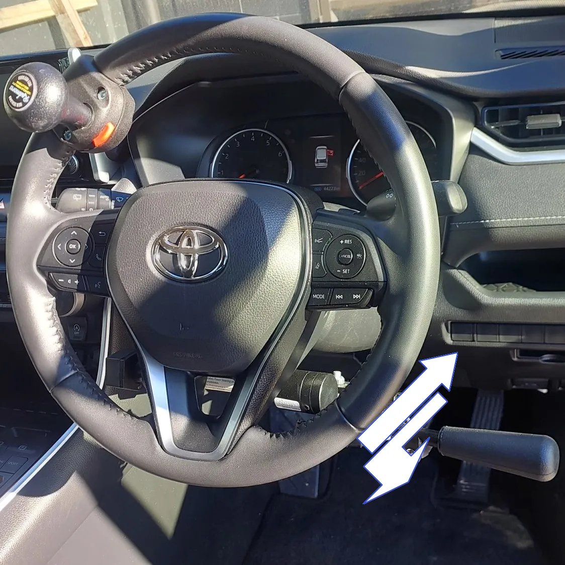 A vehicle steering wheel with control rods showing operating directions.