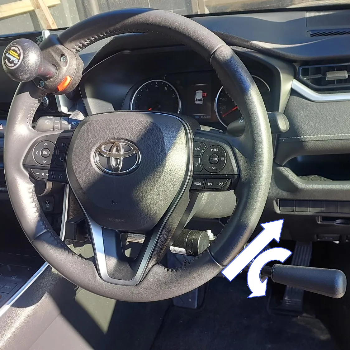 A vehicle steering wheel with control rods showing operating directions.