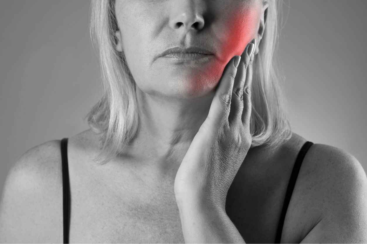 Woman experiencing tooth pain at the dentist