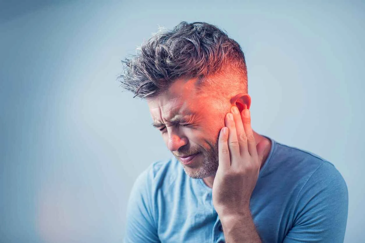 Person holding jaw with ear pain caused by wisdom teeth