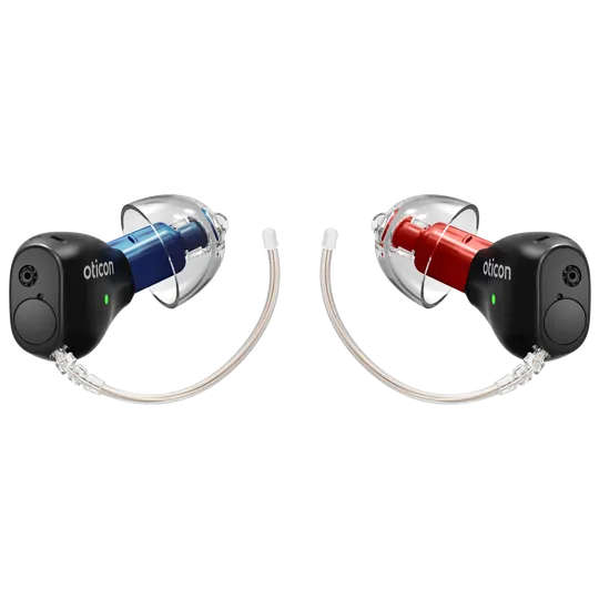 Pair of Oticon Zeal in-ear hearing aids, one blue and one red, connected by clear tubes.