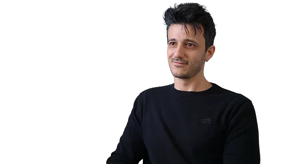 Portrait of a man with dark hair wearing a black sweater, looking slightly to the right with a neutral expression.
