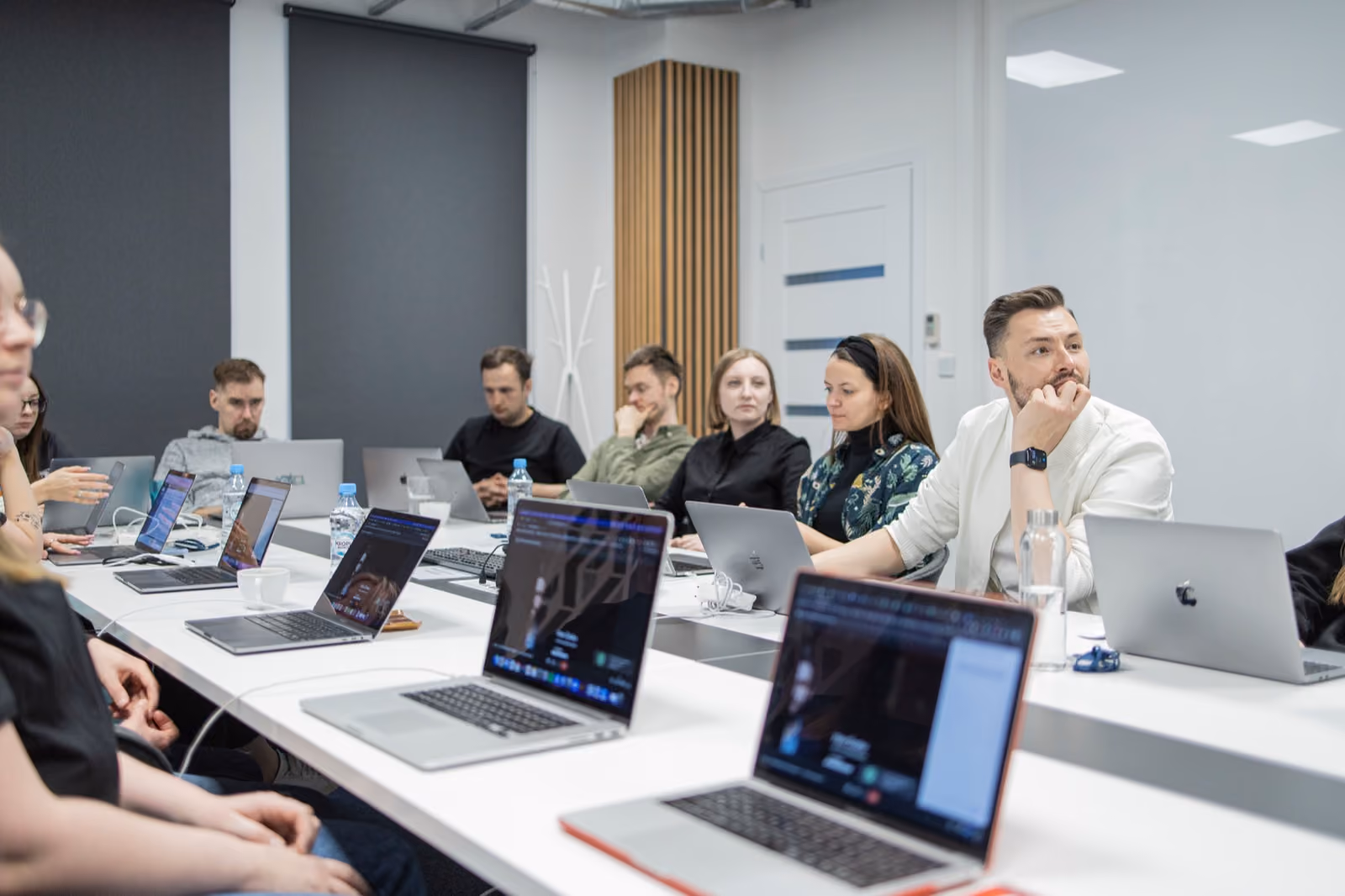 STX Next data engineering team in a workshop session with laptops around a conference table