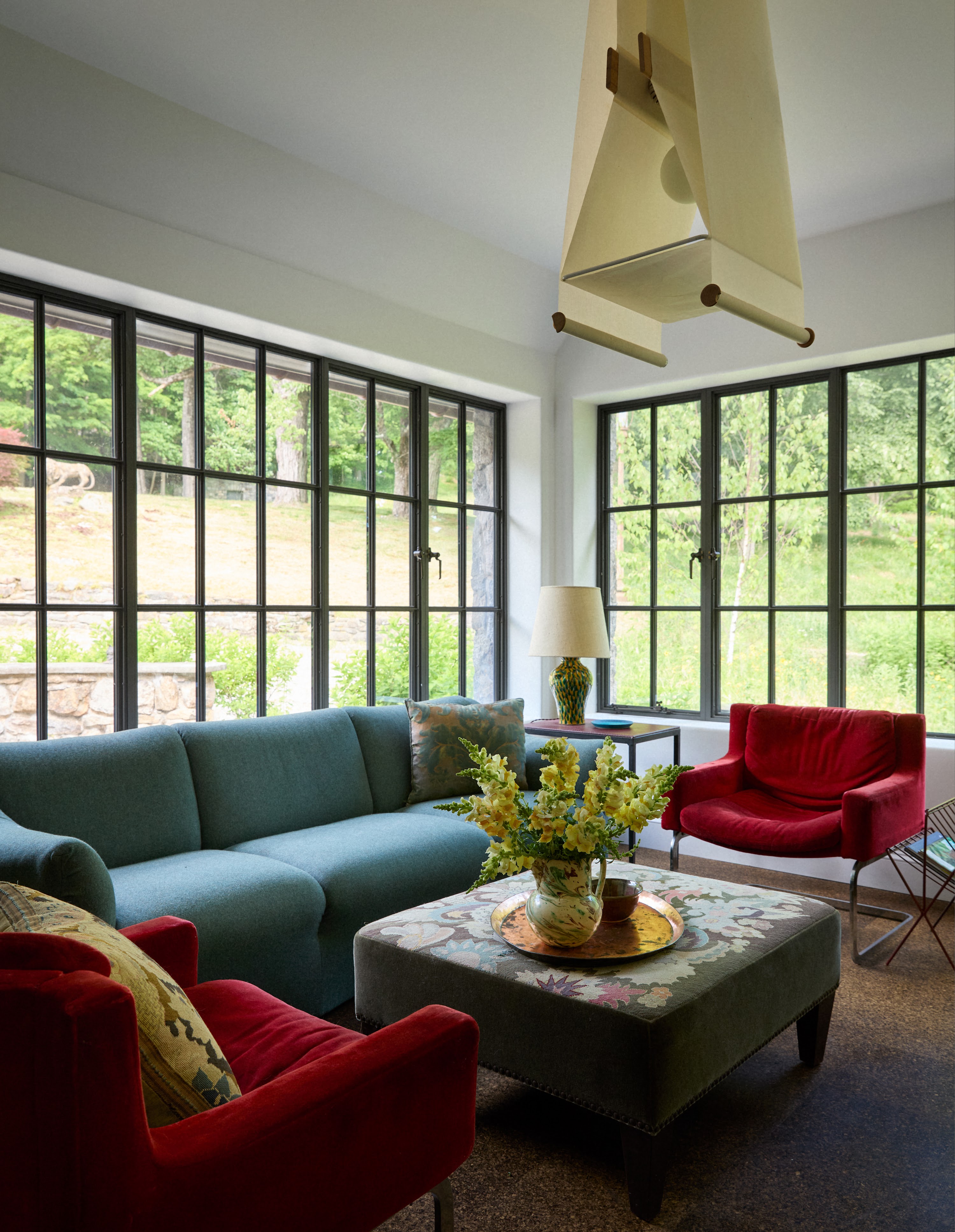 Upstate New York sitting room with a blue sofa and red chairs