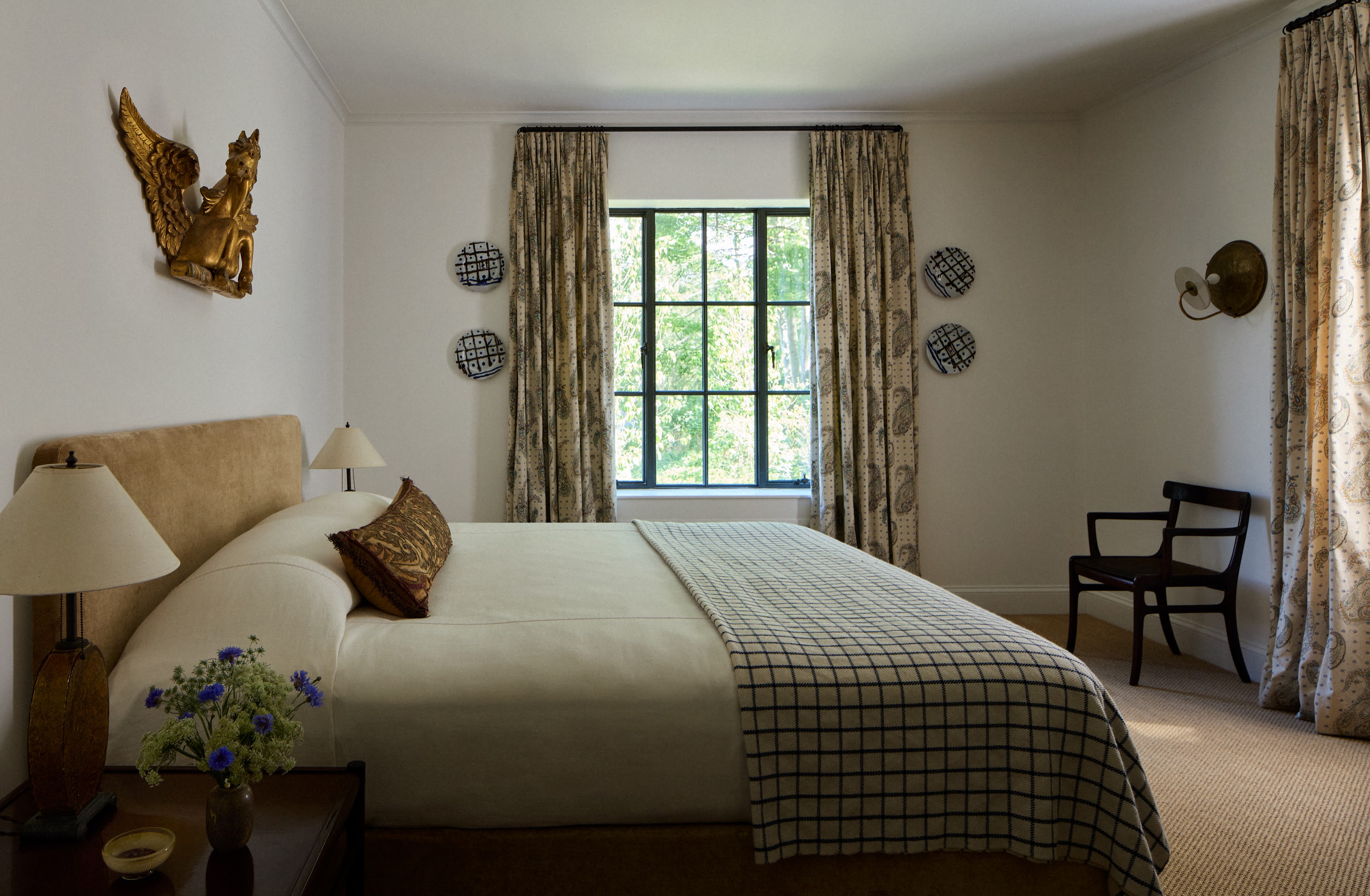 Upstate New York bedroom with a checked bed cover and patterned curtains