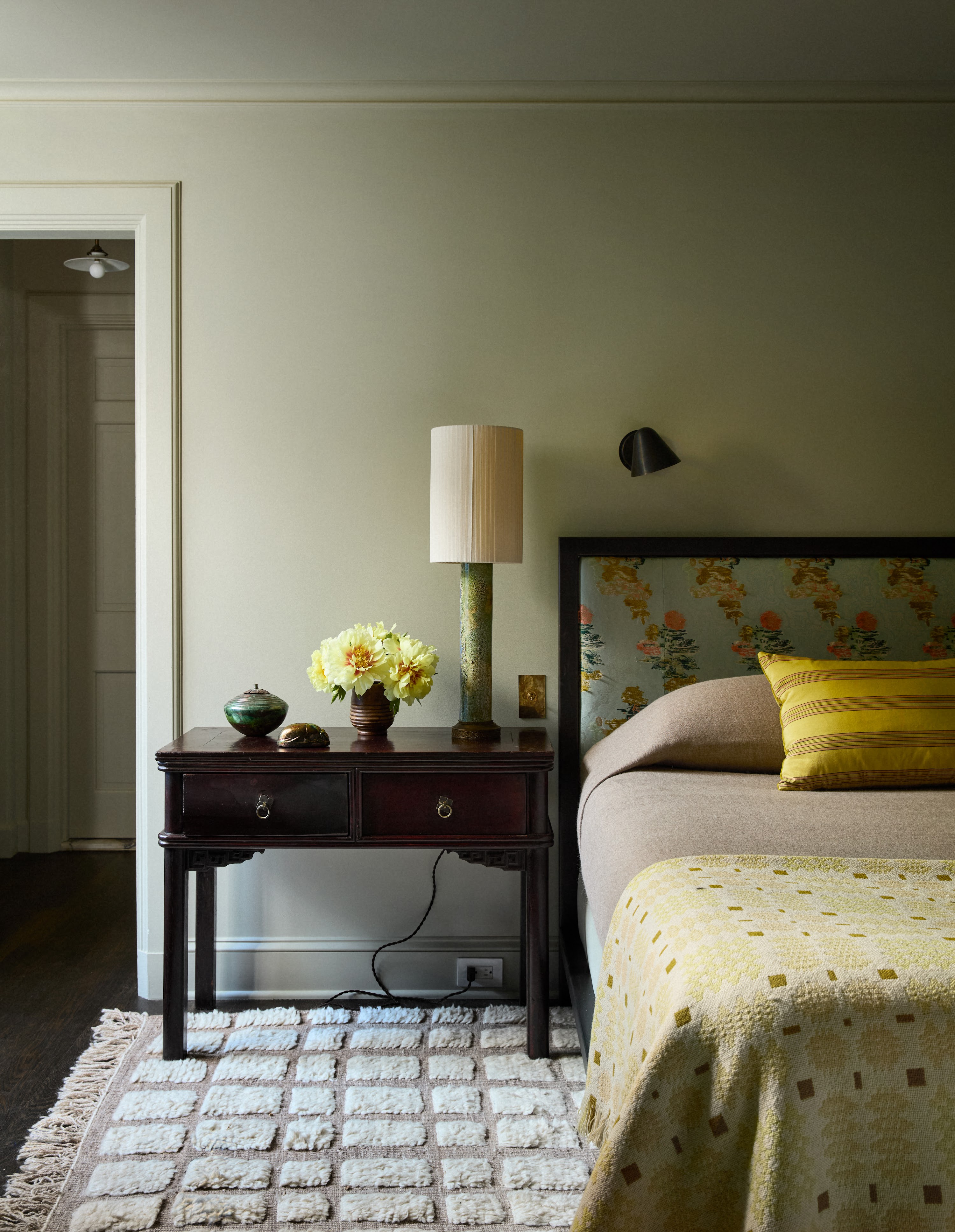 Upstate New York bedroom with a patterned headboard and bedside table