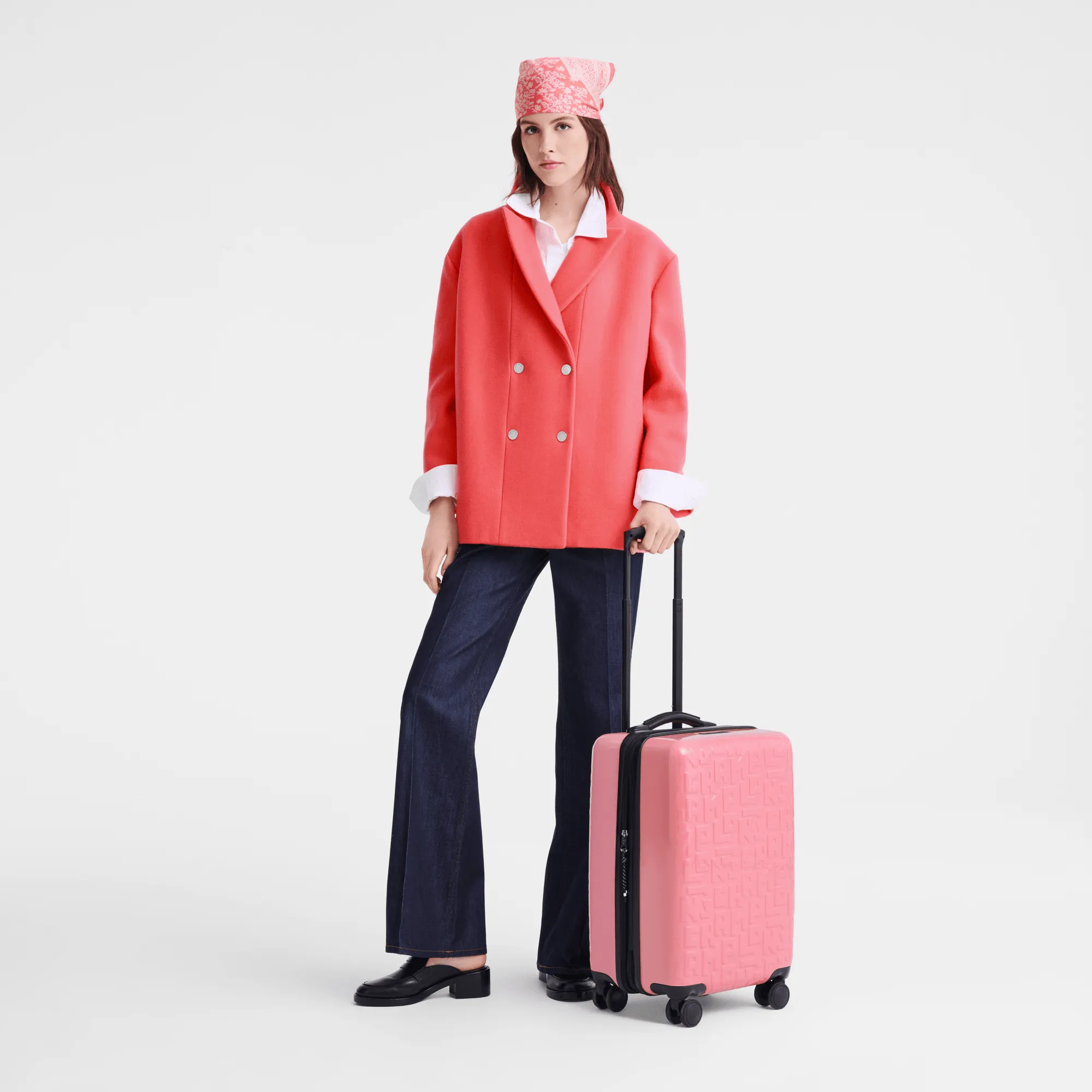 femme avec une valise Longchamp de couleur saumon