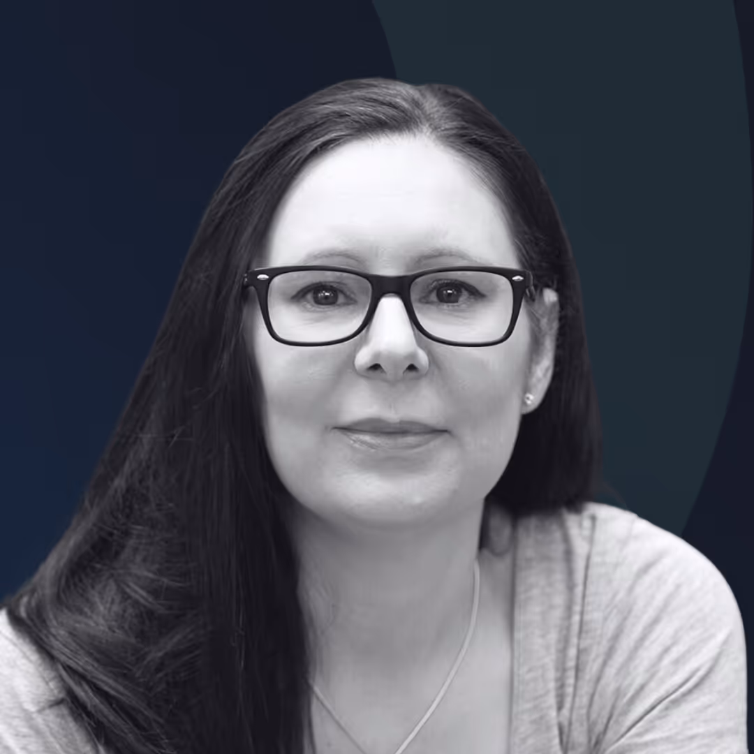 A woman wearing glasses is looking at the camera.