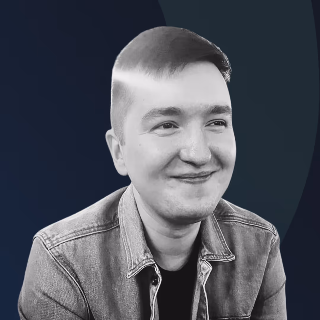A black and white photo of a smiling man.