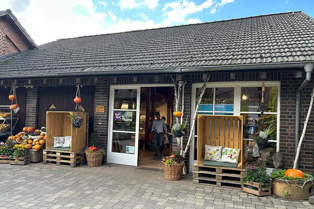 Historisches Gehöf mit Hofladen unter blauem Himmel, Hofmarkt Oberschuirshof, Essen, Ruhrgebiet