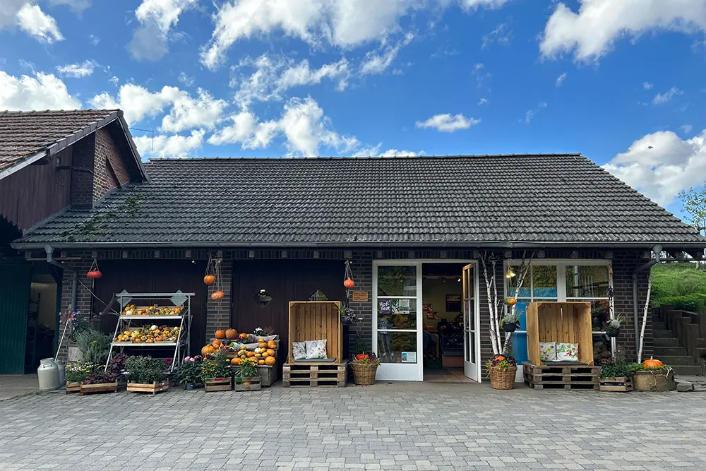 Historisches Gehöf mit Hofladen unter blauem Himmel, Hofmarkt Oberschuirshof, Essen, Ruhrgebiet