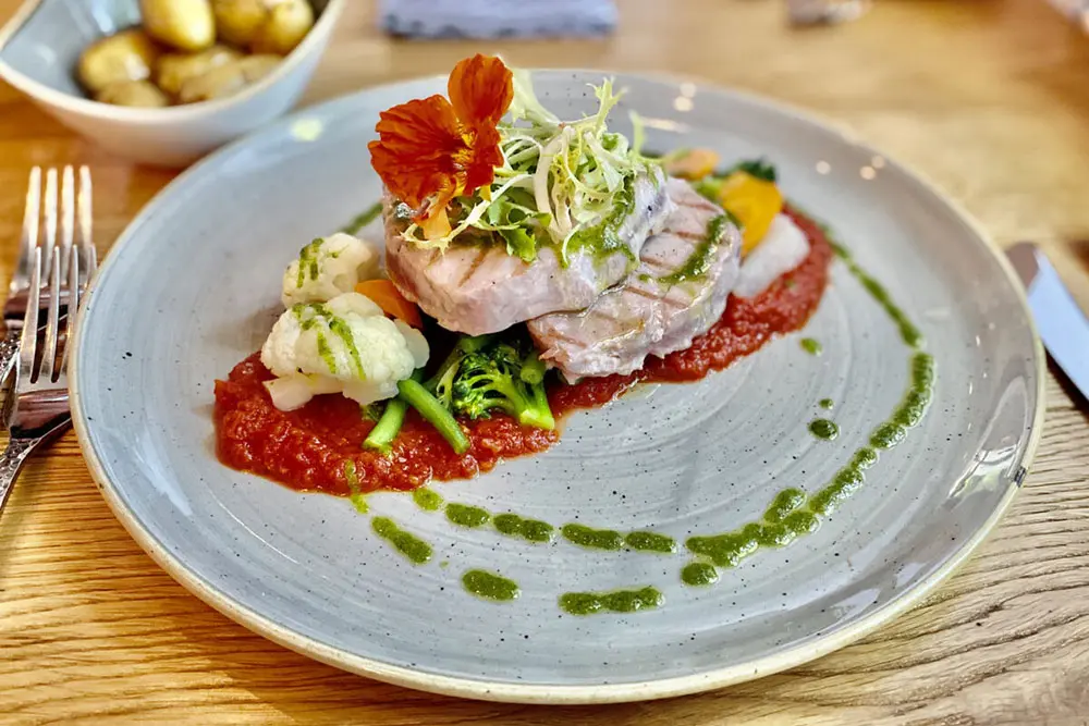 Kalbskotelett mit saisonalem Gemüse auf einem grauen Steingut-Teller