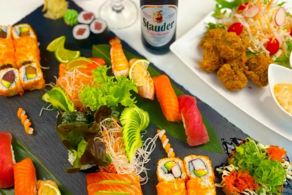 Verschiedene Arten von Sushi auf Platte und Teller mit Flasche Stauder Pils