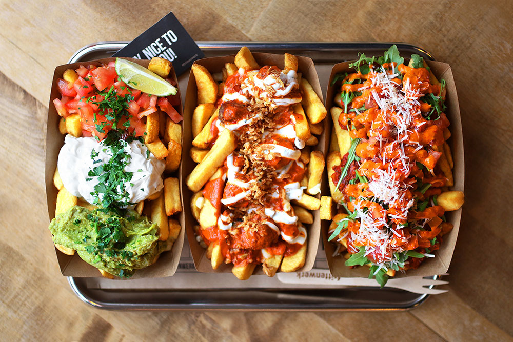 Kanadische Poutines in Schälchen auf Tablett