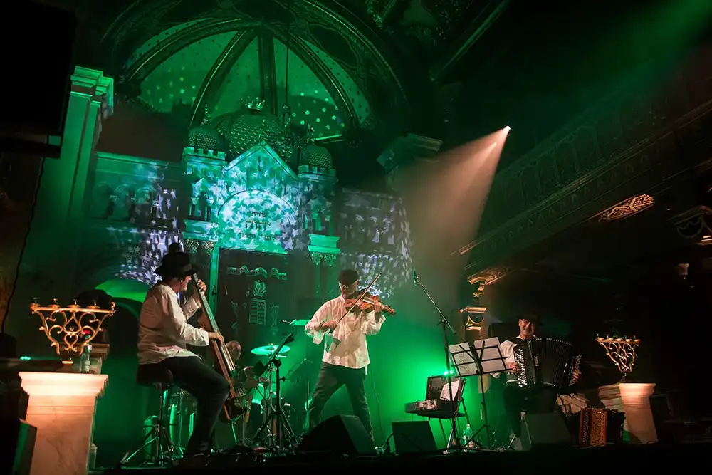 Die Musiker der Klezmer-Band Kroke auf der Bühne an Bratsche, Akkordeon und Kontrabass während eines Live-Konzerts