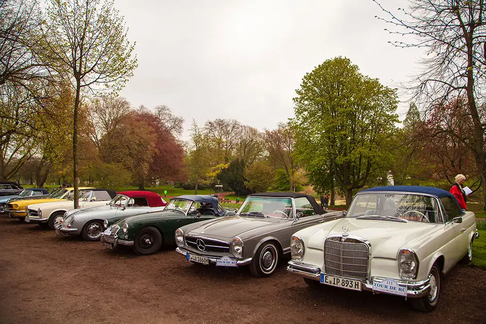 Klassische Oldtimer vor idyllischer Naturkulisse unter blauem Himmel, Stadtgarten Essen, Ruhrgebiet