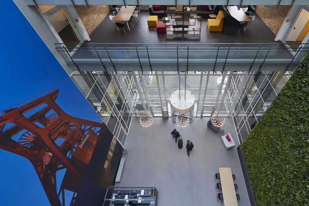 Modernes Foyer in Essen aus der Vogelperspektive mit großer Zeche Zollverein Fotowand und bepflanzter Wand