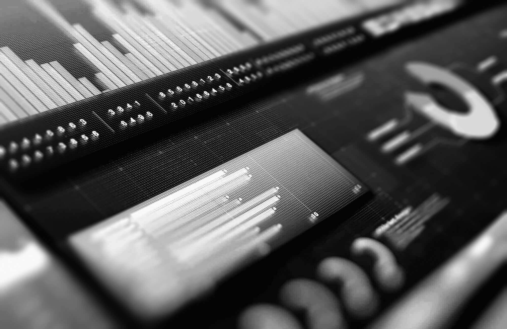 Close-up of a digital data dashboard showing various bar graphs, numerical data, and a doughnut chart.