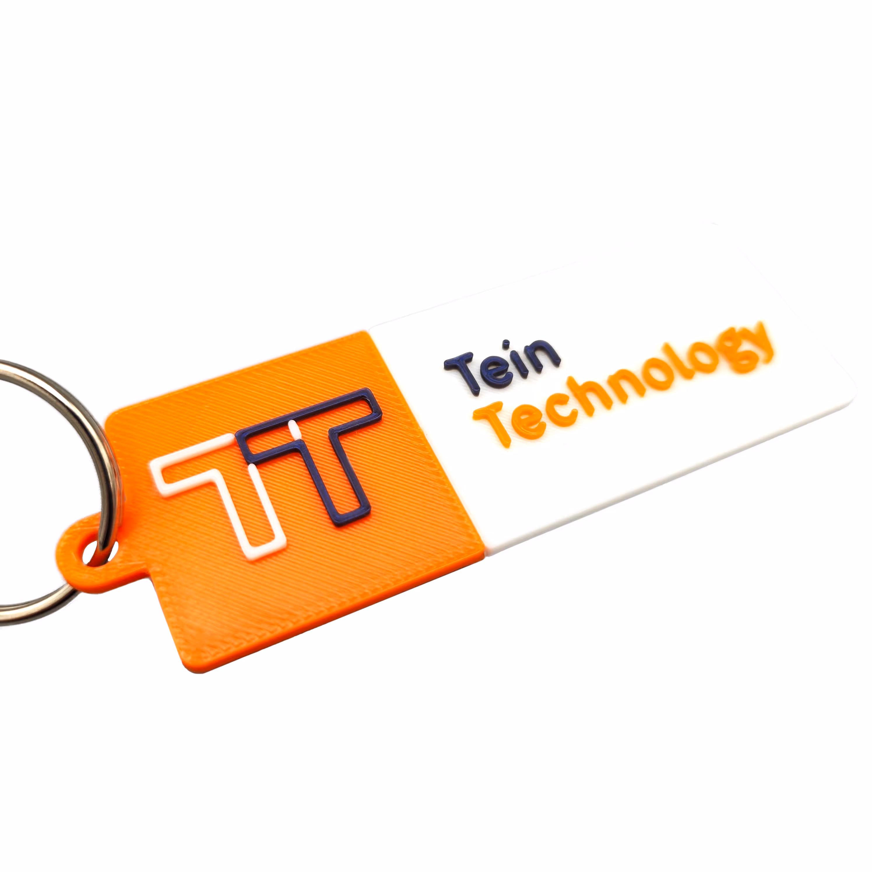 Close-up van 3D-geprint sleutelhanger met logo Tein Technology in drie verschillende kleuren.