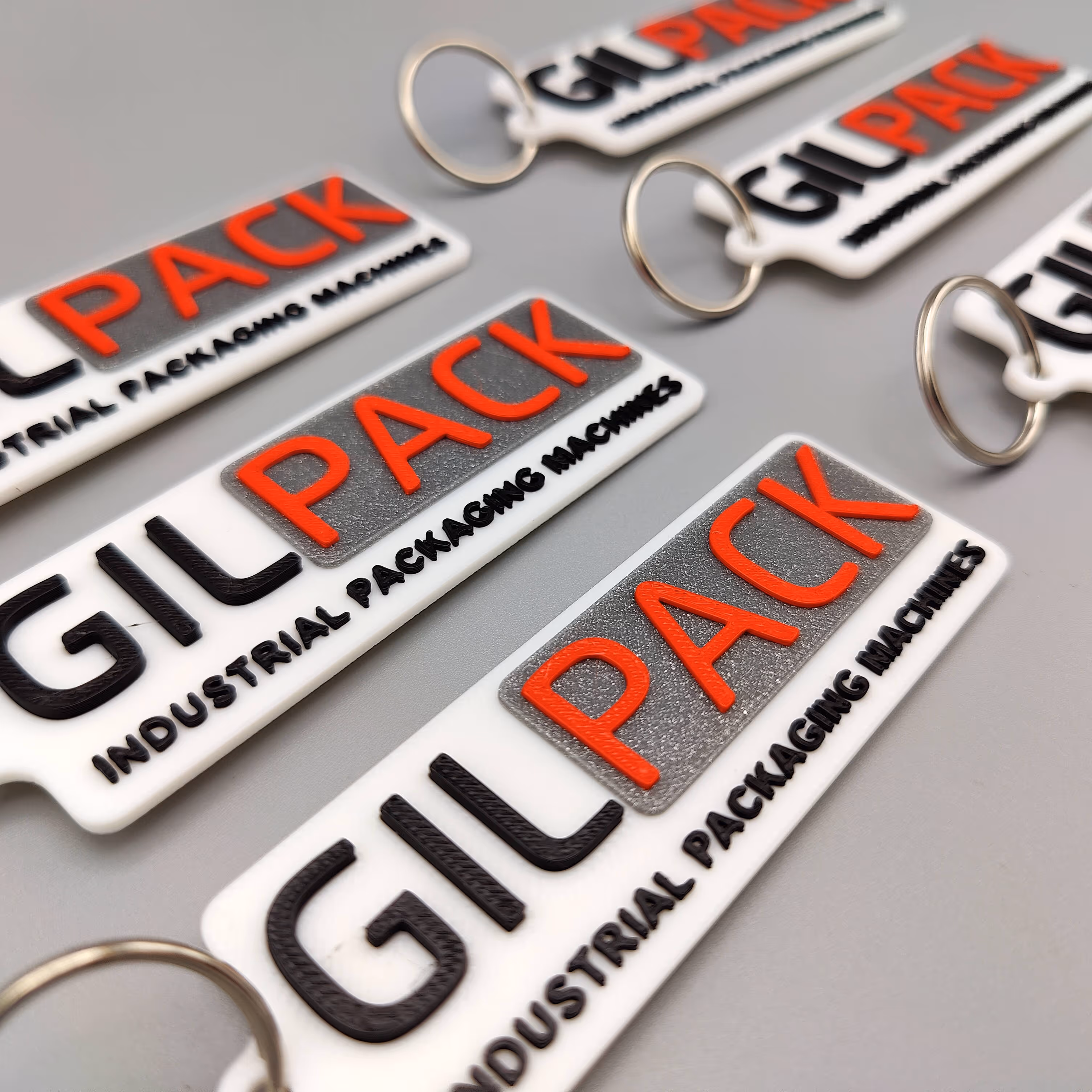 Close-up van een sleutelhanger met glinsterende afwerking en geïntegreerd logo voor Gilpack, lokaal vervaardigd.