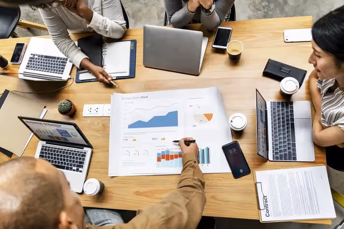 A group of people in a meeting reviewing a project report.