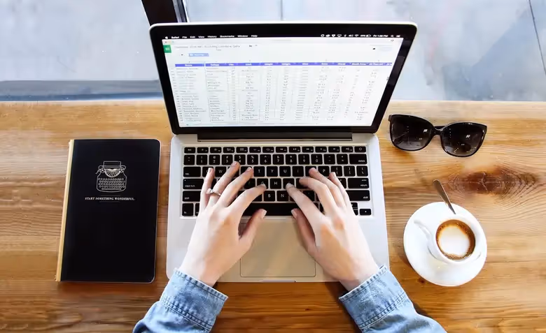 A photo of a person working on a project report in an Excel file.