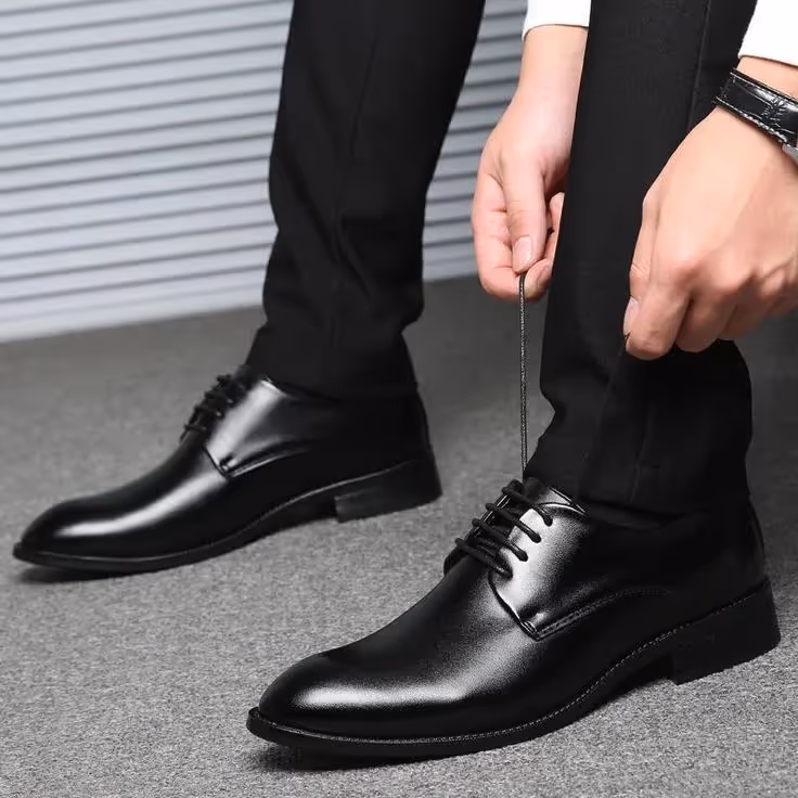 Business Casual Dress Code for Client-Side Project Managers: An image of a person tying the lace of the leather shoes.