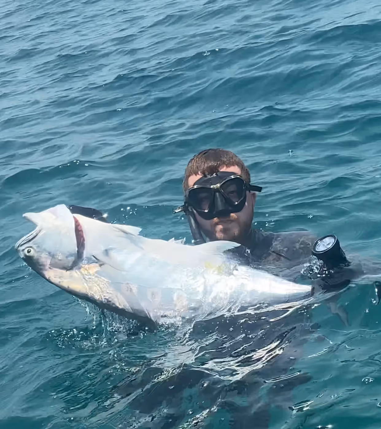 Meet Ezzeddin, Our Team Member in Dubai, UAE: A man showing the fish he just caught