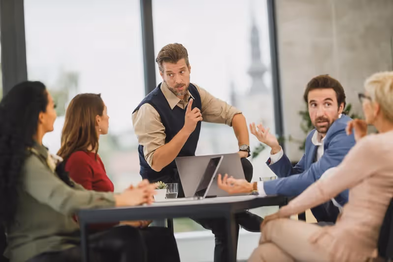 Ultimate Guide to Project Management Salaries in Australia: A project officer conducting a meeting with other four professionals.