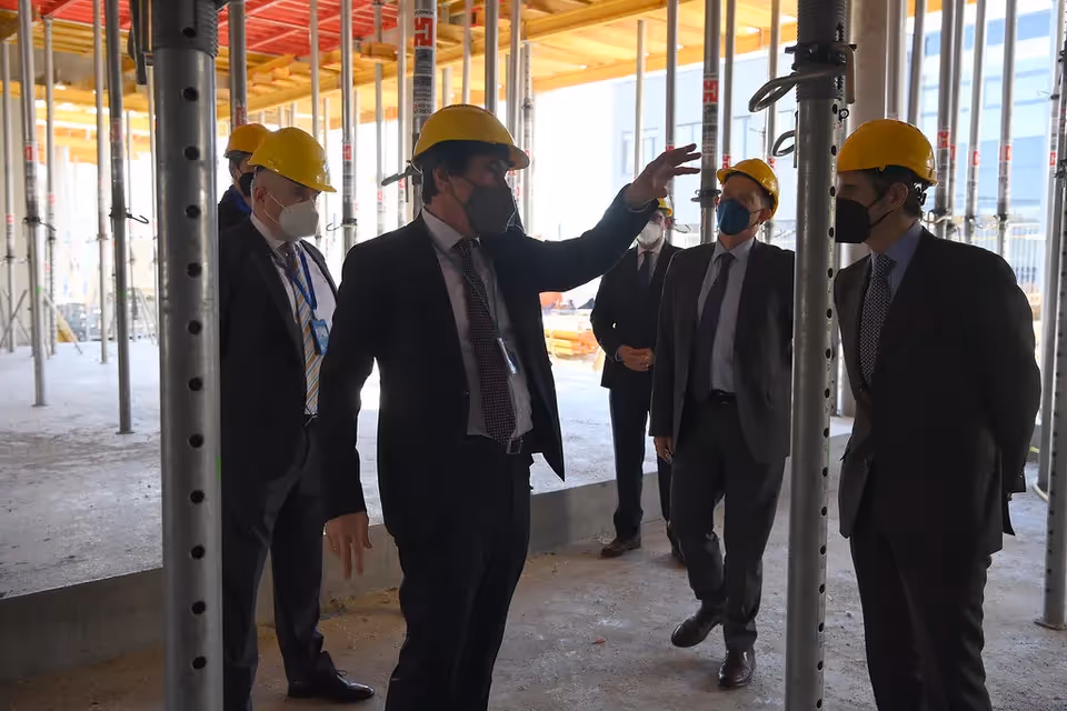 Ultimate Guide to Project Management Salaries in Australia: Project consultant wearing a mask and a safe helmet discussing with other men.