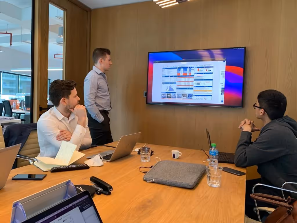Meet our first MENA customer: Compass Project Consulting: A group of project management professional looking at data on the TV in an office 