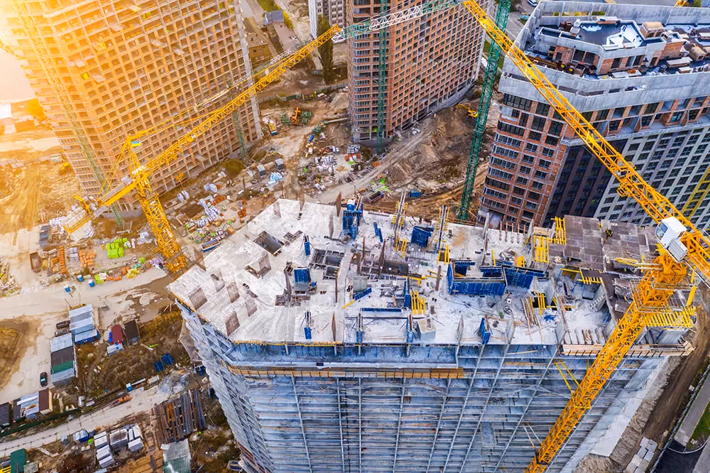 Aerial view of a large-scale construction site with cranes and buildings.