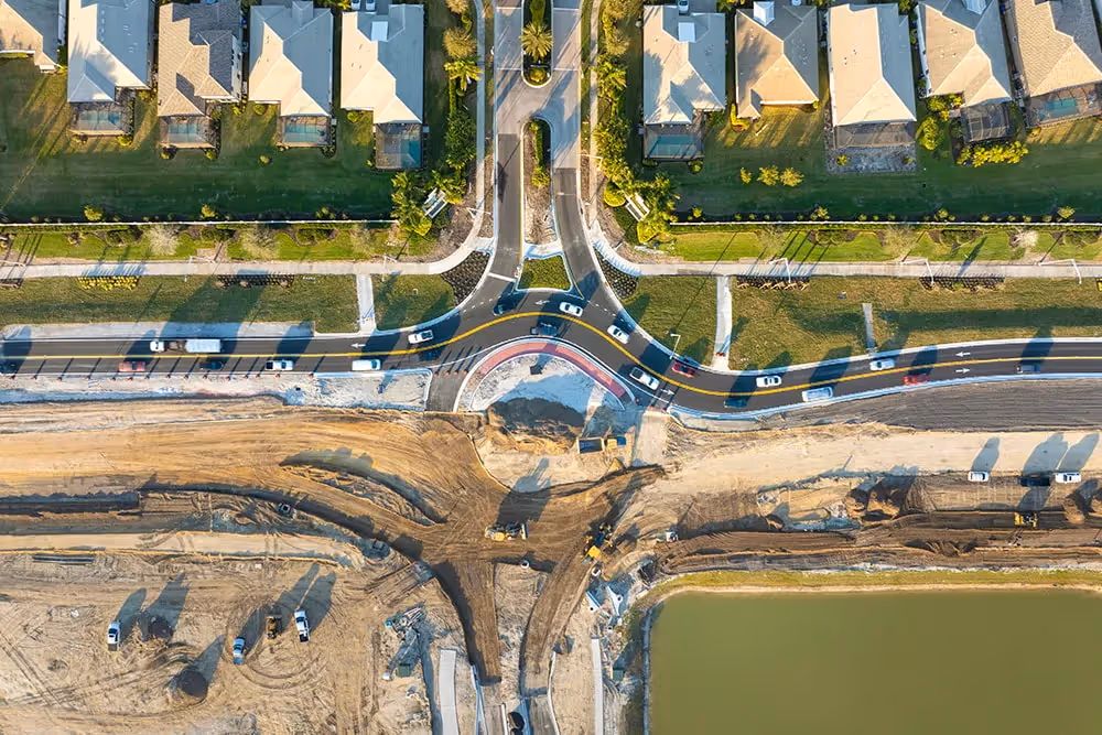 Aerial view of a developing roadway and residential neighborhood.